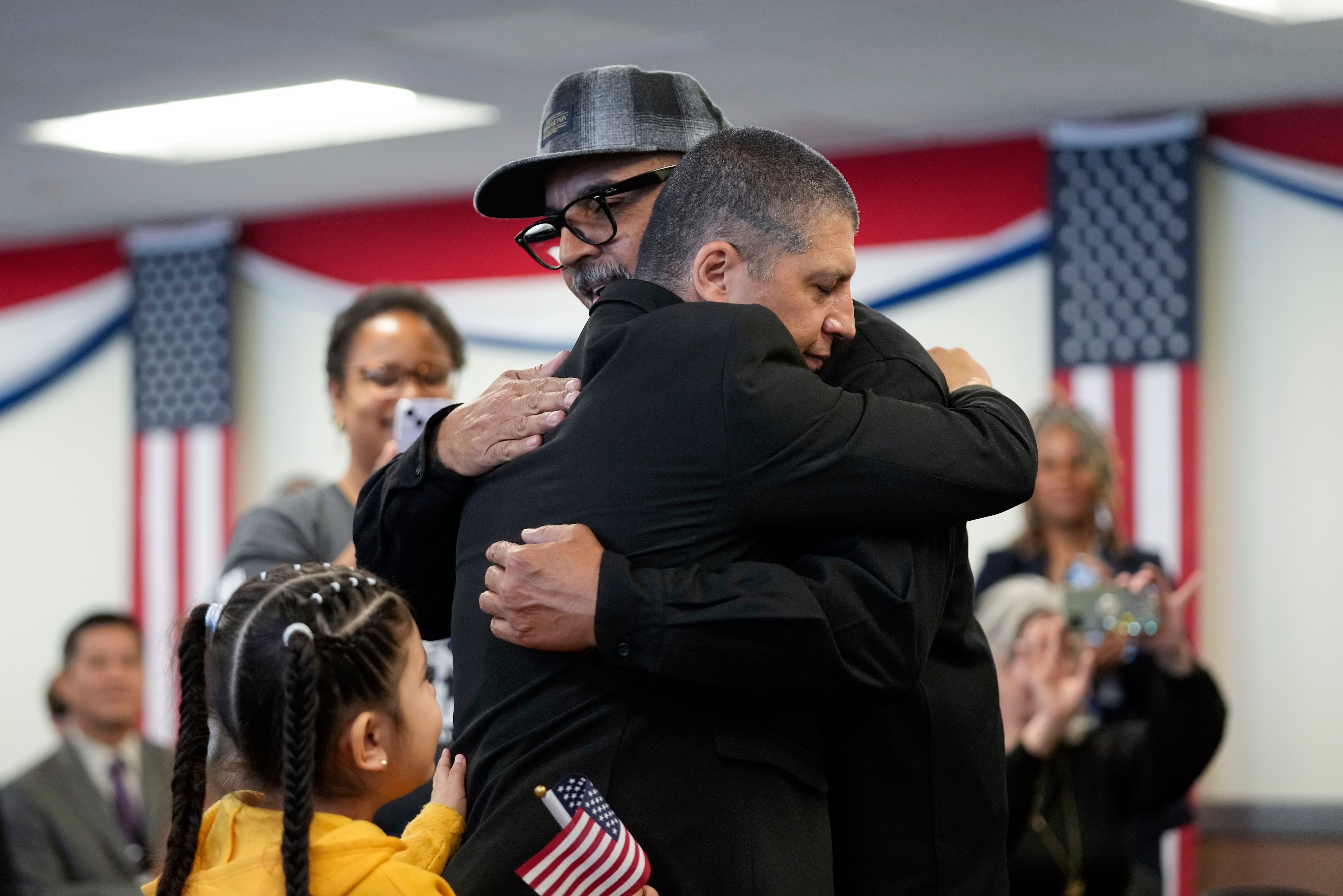 Deported veterans Mauricio Hernandez Mata, center right, and Leonel Contreras embrace after being sworn in as U.S. citizens at a special naturalization ceremony Wednesday, Feb. 8, 2023, in San Diego.