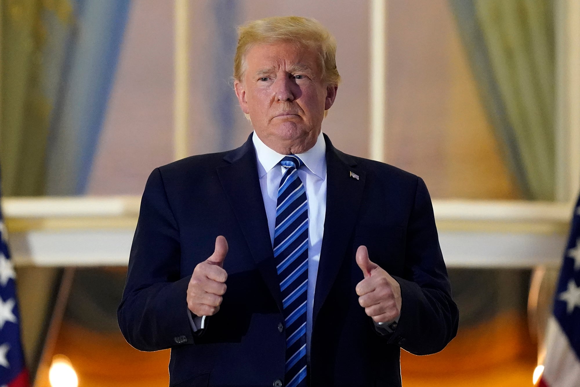 President Donald Trump stands on the balcony outside of the Blue Room as returns to the White House Monday, Oct. 5, 2020, in Washington, after leaving Walter Reed National Military Medical Center, in Bethesda, Md.