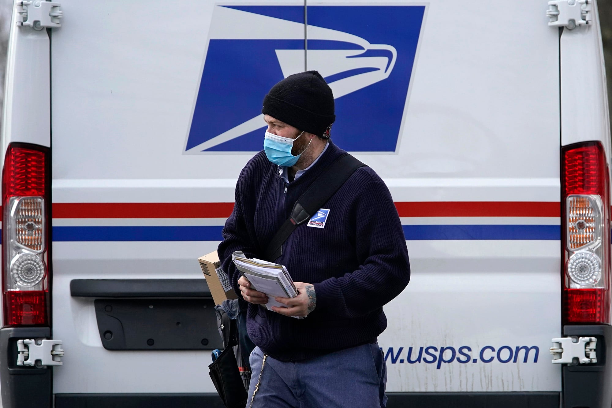 Postal carrier Josiah Morse heads out to deliver mail and packages, Wednesday, Feb. 3, 2021, in Portland, Maine.