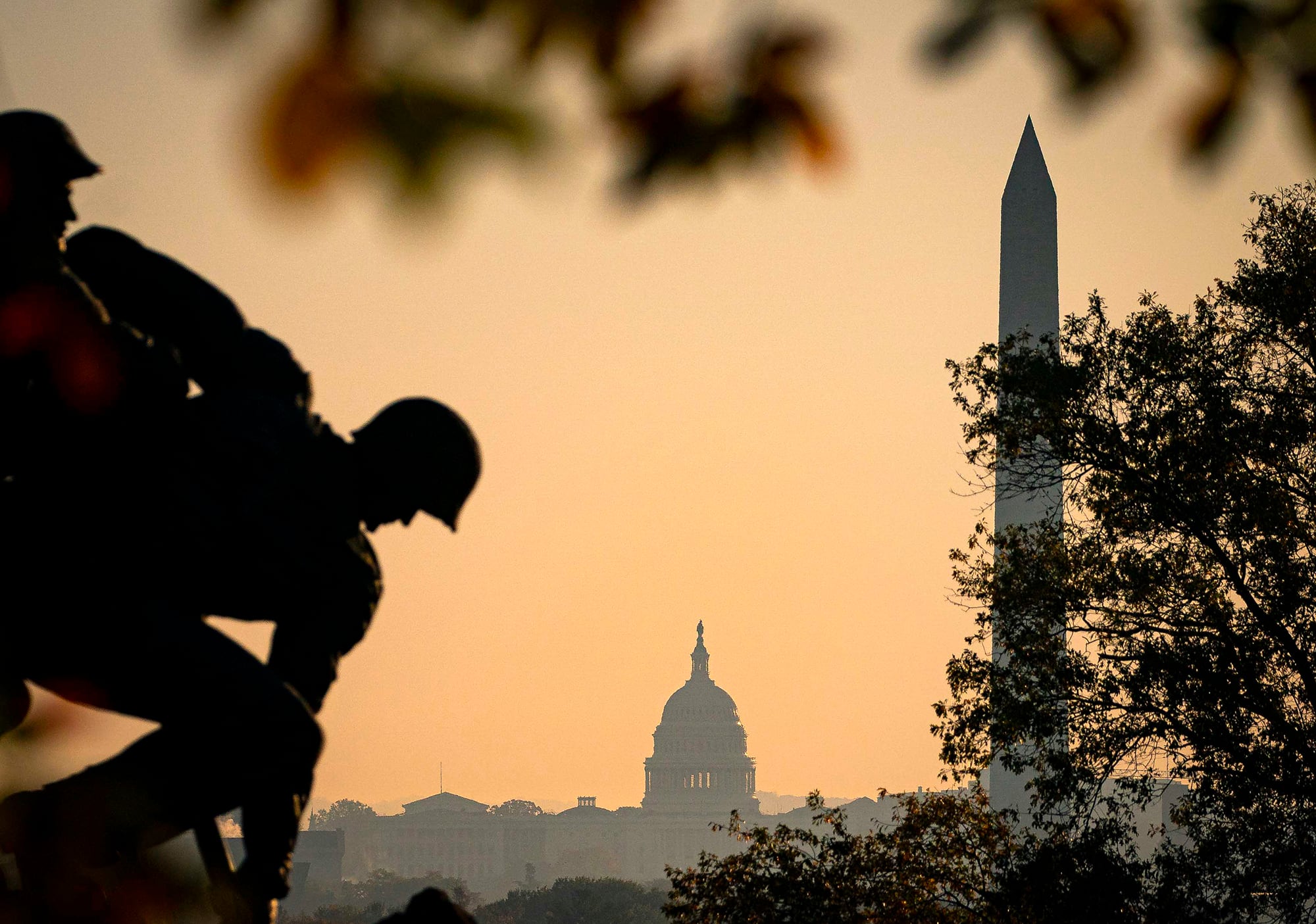 The U.S. Marine Corp's Iwo Jima Memorial can be seen as the morning sun begins to rise behind the U.S. Capitol and Washington Monument on Nov. 7, 2020, in Arlington, Va.