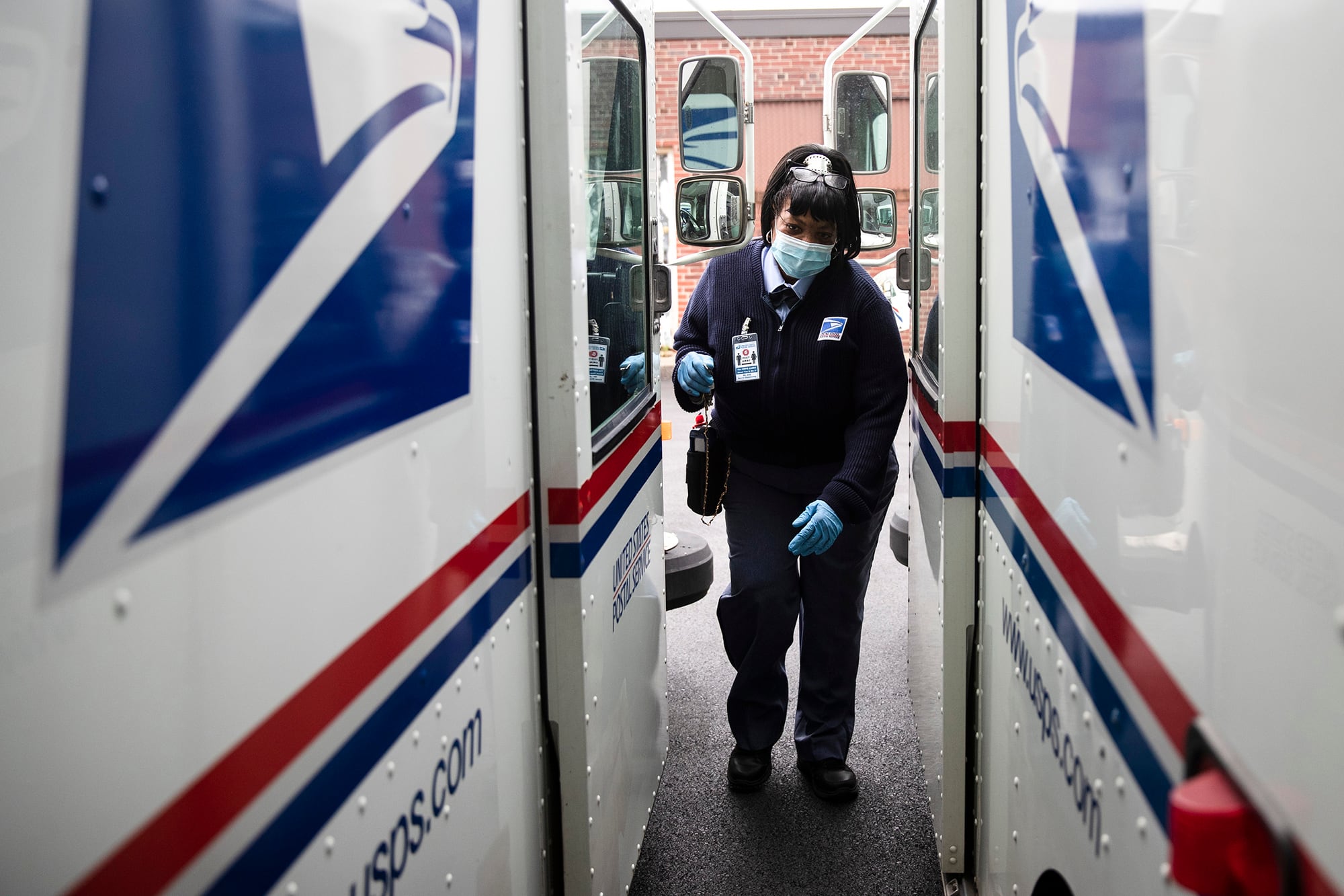 In this May 6, 2020, photo, United States Postal Service carrier Henrietta Dixon gets into her truck to deliver mail in Philadelphia.