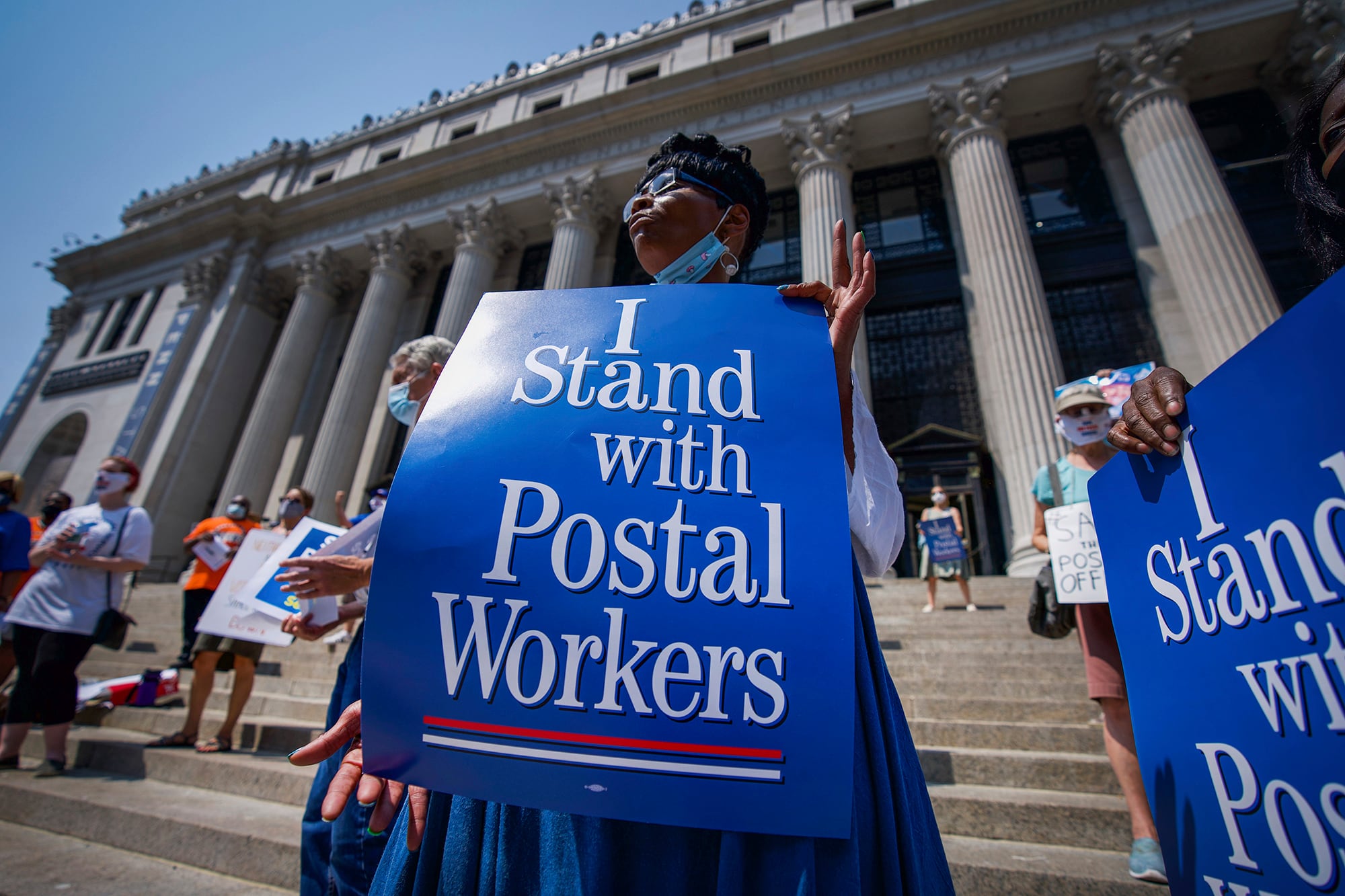 Retired postal worker Glenda Morris protests postal cutbacks, Tuesday, Aug. 25, 2020, in New York.