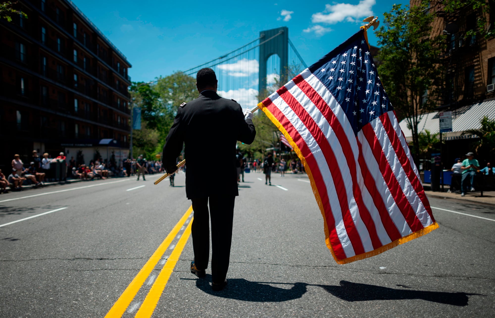 A veteran carries an American flag as he marches on the street May 27, 2019, during the 152nd Memorial Day parade in the New York City borough of Brooklyn.