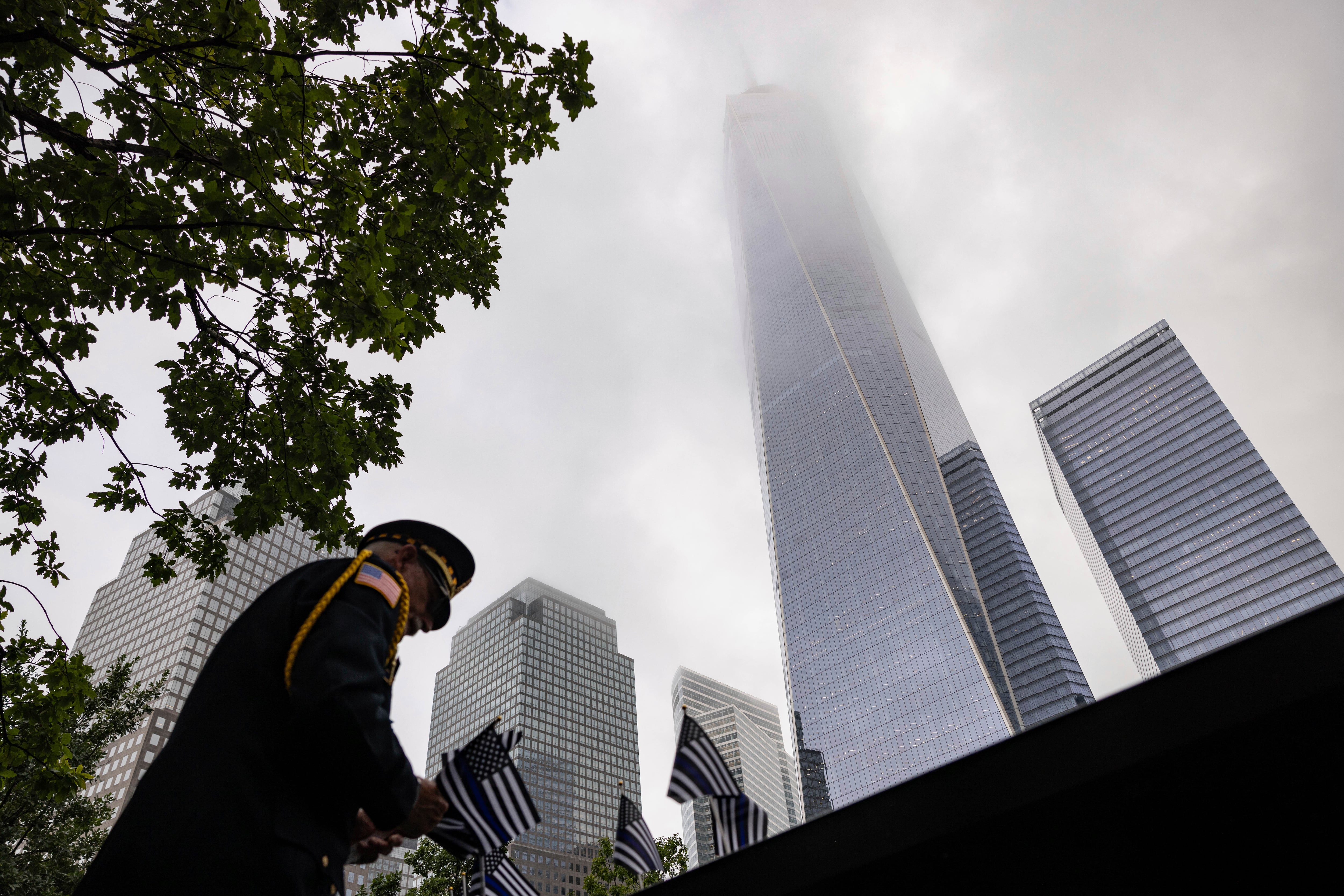 Sam Pulia places flags before the commemoration ceremony of the Sept. 11, 2001, terror attacks, Monday, Sept. 11, 2023, in New York.